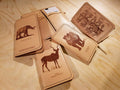 a collection of leather-bound notebooks or diaries with illustrations of various animals, including elephants, rhinos, and antelopes, printed on the covers.