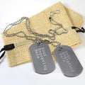 two gray metal tags with personalized text, placed on a burlap bag.
